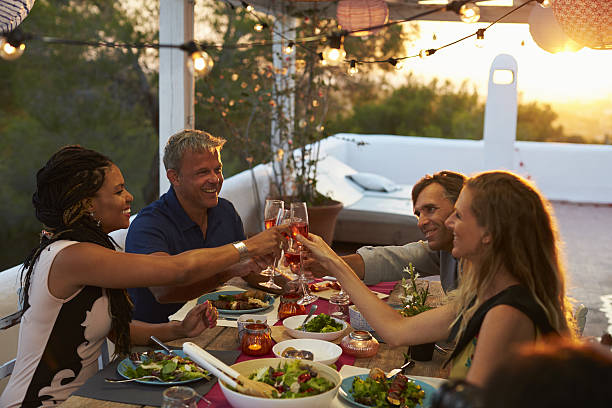 istock Two couples making a toast at dinner on a rooftop terrace 639710114