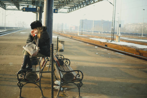 schöne junge traurige frauen warten einen zug auf dem bahnhof - leaving loneliness women railroad track stock-fotos und bilder
