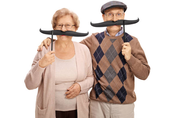 Cheerful seniors with big fake moustaches Cheerful seniors with big fake moustaches isolated on white background women movember mustache facial hair stock pictures, royalty-free photos & images