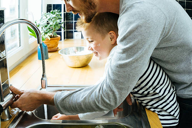istock Father Washing Sons Hands In Kitchen Sink After Cooking Together 639716006