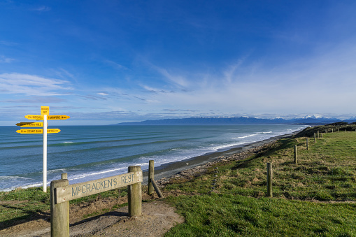 Yellow direction signs ans wooden board at Mc Cracken's Rest viewpoint, New Zealand