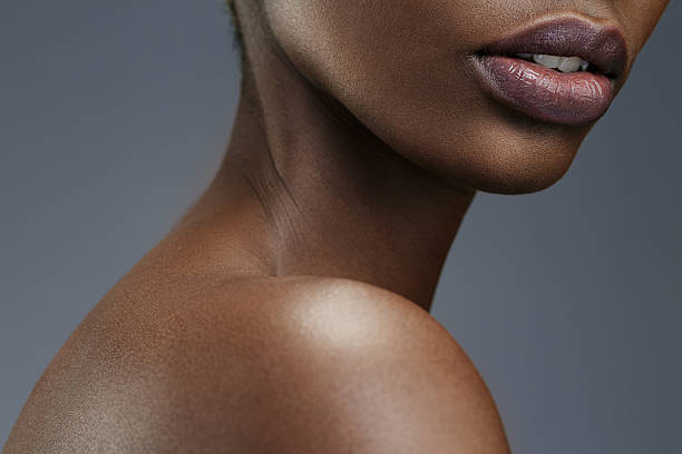 Beauty portrait   Lips  Close up  Beautiful african ethnicity  young women Lips. Close up. Beauty, fashion portrait. Original looks. Beautiful, lovely  and sensual young african girl.  Attractive African ethnicity,  slim women. Gray wall background. thin neck stock pictures, royalty-free photos & images