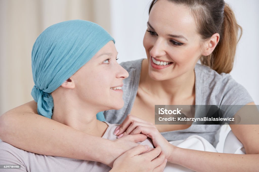 Hopeful cancer woman with friend Hopeful cancer woman wearing headscarf, talking with friend Cancer Cell Stock Photo