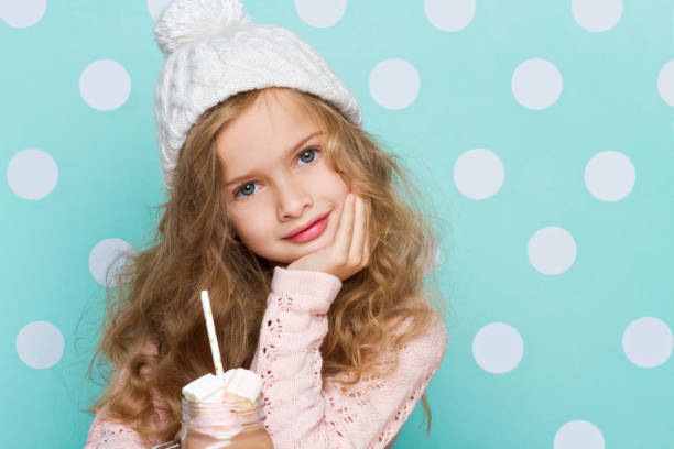 istock Young girl in hat drinking hot chocolate with marshmallows 639722058