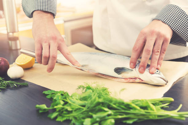 istock chef preparing salmon fish for cooking in kitchen 639722380