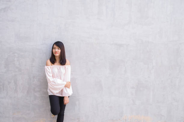 istock young woman against concrete wall. 639724814
