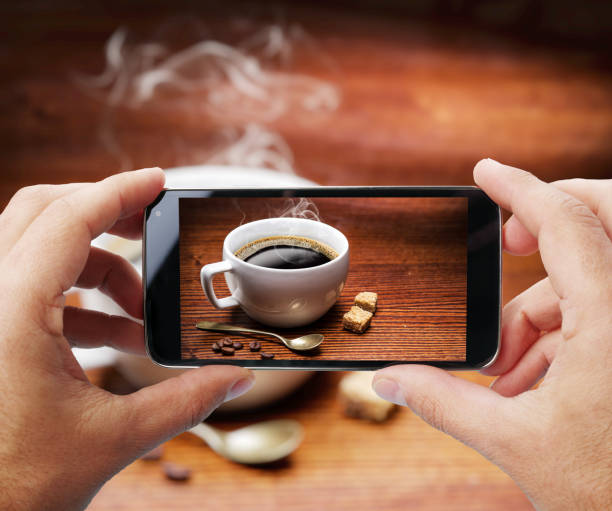 Taking photo of cup of coffee by smartphone.