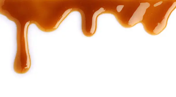 Melted caramel dripping isolated on white background