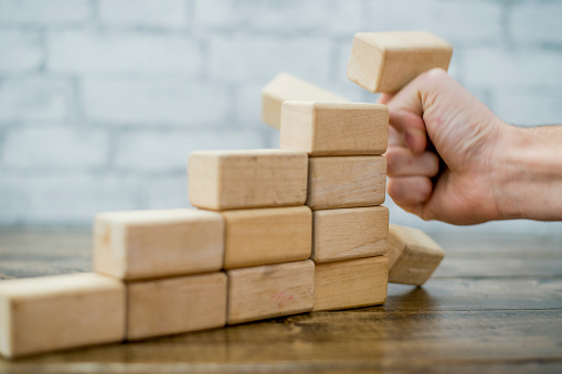 An anonymous hand punches a 3D business growth graph, to symbolize failure.