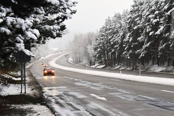 voitures sur route d’hiver avec de la neige. circulation dangereuse par mauvais temps - winter driving photos et images de collection