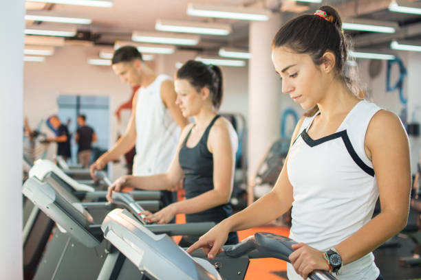 istock Sportswoman setting up difficulty level on a treadmill in gym. 639747098