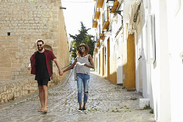istock Couple on holiday walking in Ibiza streets with a guidebook 639747772
