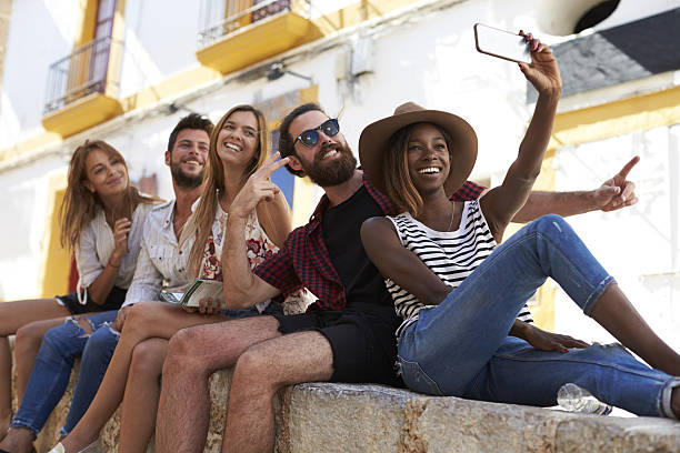 istock Five friends sitting on a wall in Ibiza taking a selfie 639748166