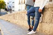 Couple leaning against a wall in Ibiza, Spain, low section