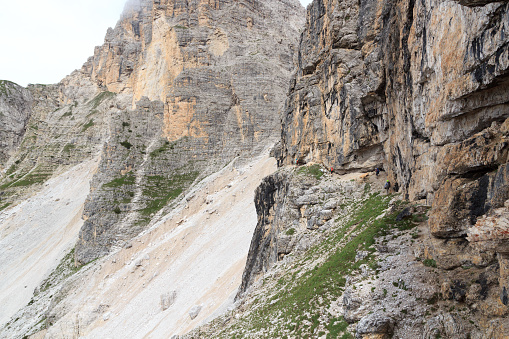 Auronzo, Italy - August 2, 2016: People climbing the Via Ferrata Severino Casara in Sexten Dolomites with mountain panorama, South Tyrol. The Dolomites are particularly renowned for their dramatic high mountain via ferratas.