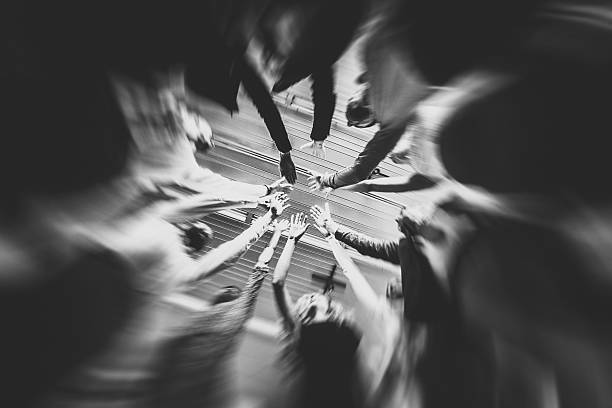 Low angle view of a group of business people standing in a circle and joining hands