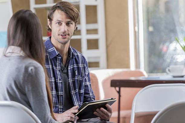 istock Mid adult man talks in support group 639755672