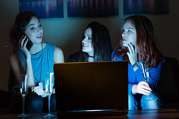 istock Three girlfriends, drinking champagne, watchng something interes 639755684