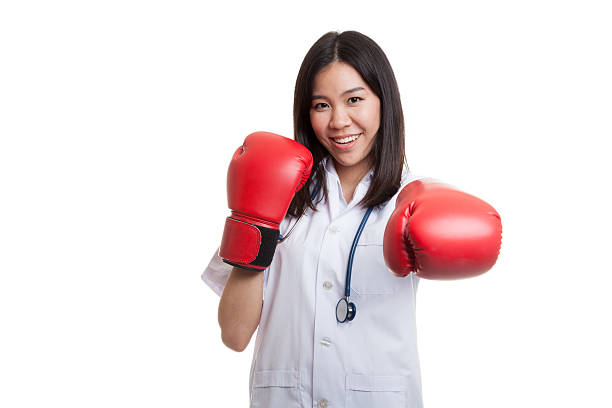 junge asiatische ärztin punch mit boxhandschuh. - fist women punching asian ethnicity stock-fotos und bilder