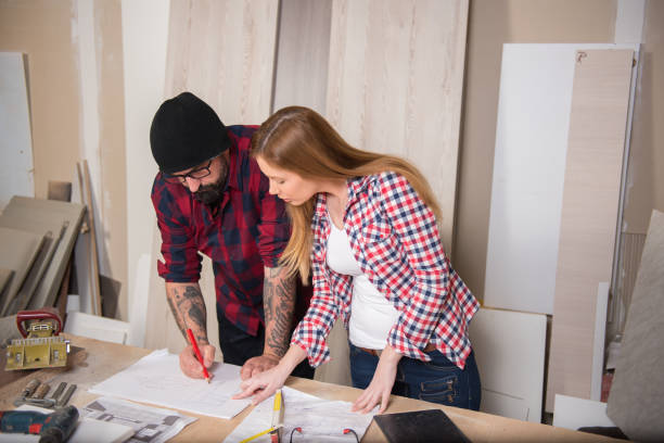 istock Woman and man using power tools in a carpenter workshop 639759916
