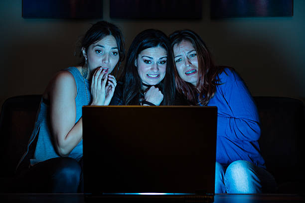 istock Three girlfriends, watchng something scary on laptop 639761668
