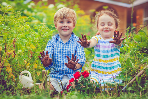 Happy little girl and boy in garden