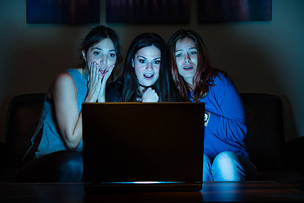 istock Three girlfriends, watchng something scary on laptop 639763026