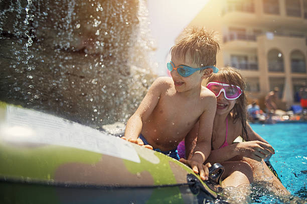 Brother and sister playing in resort pool