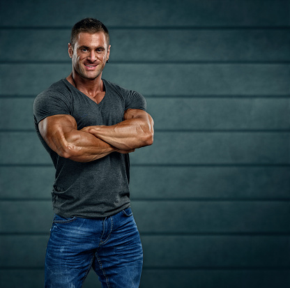 Portrait of handsome Muscular Men in t-shirt and jeans with his arms crossed