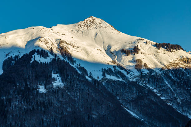 istock Snowy Mountain tops in the blue sky sun 639769602
