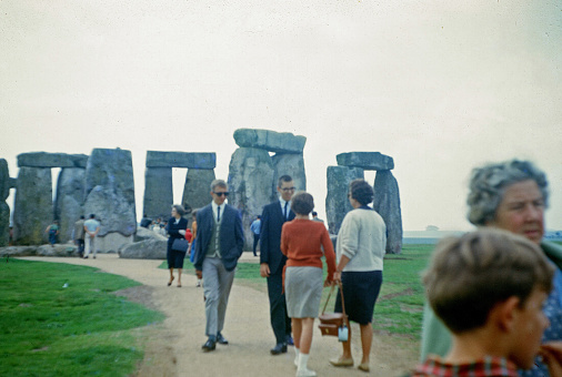 Amesbury, United Kingdom - January 1, 1970: Tourists walk past the Stonehenge monument, Amesbury, Salisbury, United Kingdom, 1970