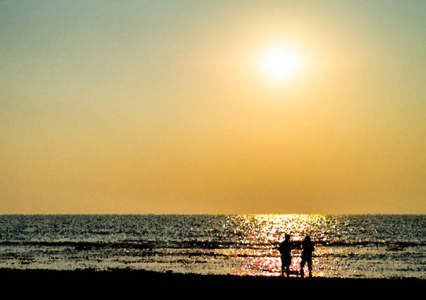 istock Two freinds silhouette meeting ocean sunset landscape backdrop 639771506