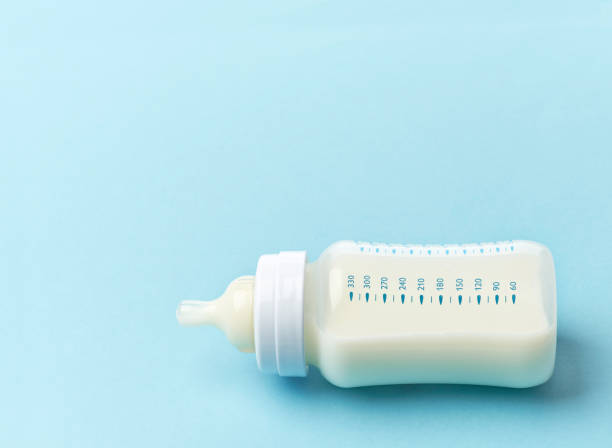 baby milk bottle baby milk bottle on blue background milk bottle stock pictures, royalty-free photos & images
