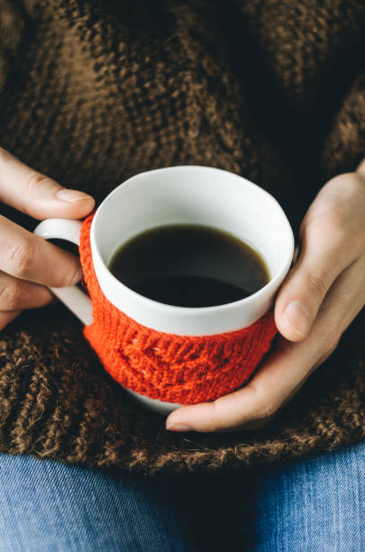istock Red Knitted woolen cup with heart pattern in female hands. 639775470