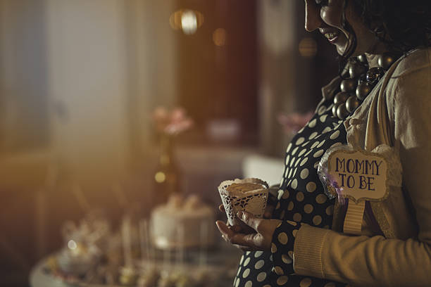 Pregnant woman holding a cupcake on her baby shower