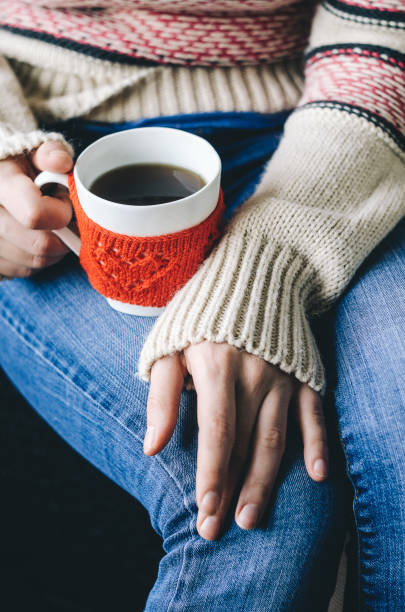 istock Red Knitted woolen cup with heart pattern in female hands. 639776700