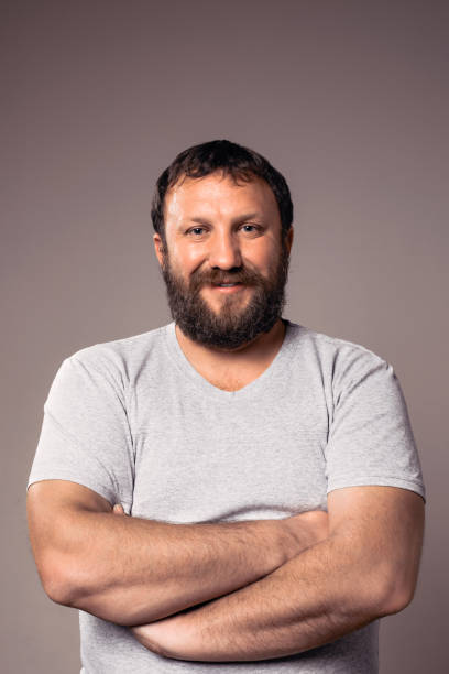 istock Happy smiling bearded guy in gray t-shirt with crossed hands. 639776830