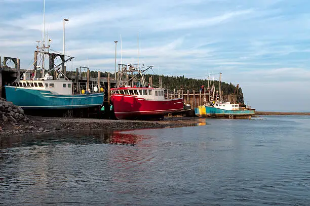 Fishing boats at low tide at the wharf in Alma, Bay of Fundy, New Brunswick, Canada. Home of the largest tides in the world.
