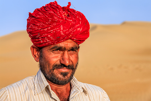 Portrait Indian man wearing turban, sand dunes, Rajasthan, India