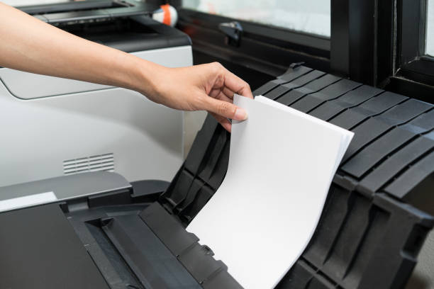 istock woman hand putting a paper into a copying device 639782306