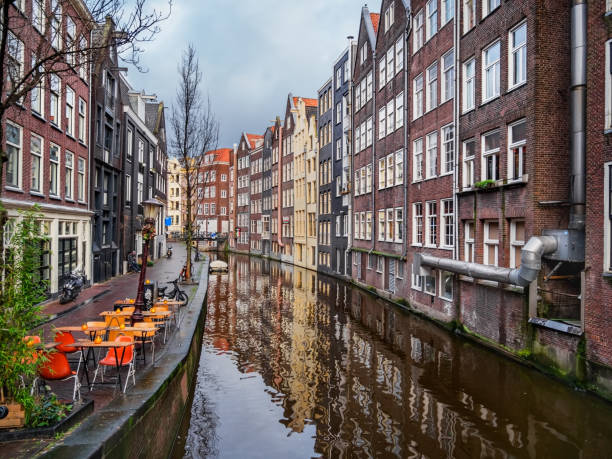 Colorful Amsterdam canal with traditional buildings and street caffee stock photo