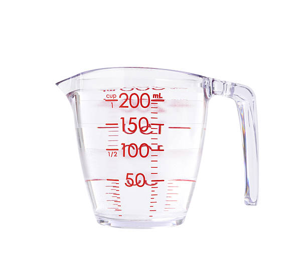Measuring cup full of water on white background, isolated on white background with clipping path.
