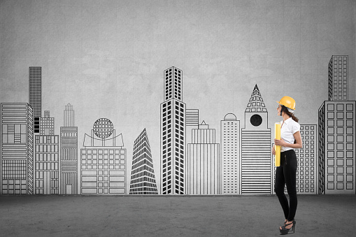 Portrait of female architect holding blueprint in front of cityscape on wall, growth concept
