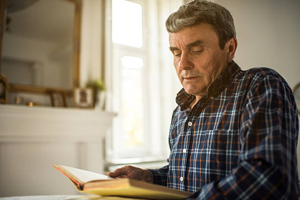 istock Relaxed senior man reading a book at home. 639793950
