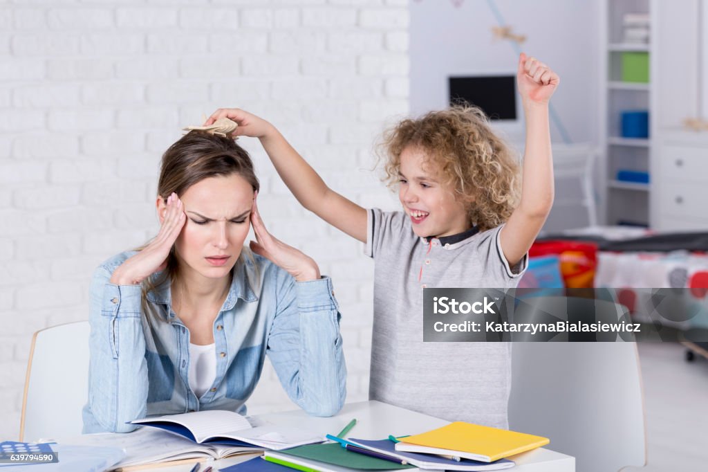 Child annoying his mother Child annoying his tired mother with headache Attention Deficit Hyperactivity Disorder Stock Photo