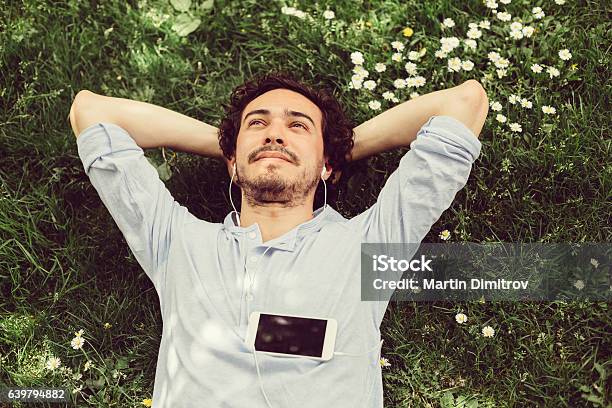 Dreamy Man In The Grass Stock Photo - Download Image Now - Men, Relaxation, Day Dreaming