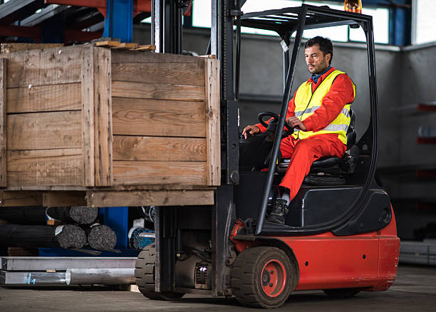 istock Mid adult worker driving forklift with palette in distribution warehouse. 639796688