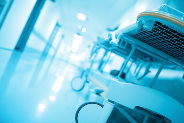 Gurney in hospital corridor, illuminated by white light, defocused