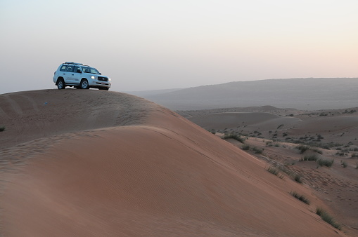 Oman desert, Oman - December 30, 2013: White Toyota Land cruiser scaling dunes in the desert on December, 30, 2013. Oman