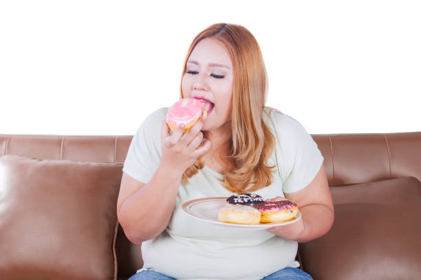 istock Blonde woman eats donuts on sofa 639803014